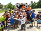 A group of children standing in front of an ambulance.