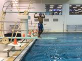 A man standing in the pool with his arms raised.