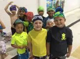 A group of children wearing swim caps and goggles.