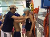 A man and woman in swimming trunks are standing by the pool.