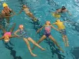 A group of children swimming in the pool.