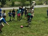 A group of kids playing soccer on the grass.