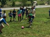 A group of kids playing soccer on the grass.