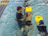 A man and child in the water with yellow floats.