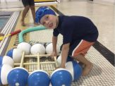 A young boy is playing with some water balloons.