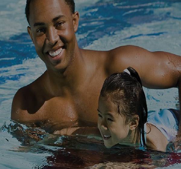 A man and child swimming in the water.