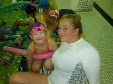 A woman and child sitting on the floor in front of some toys.