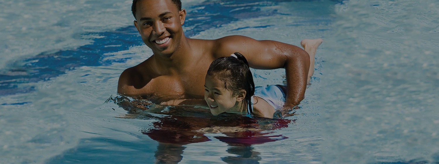 A man and child swimming in the pool.